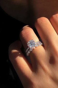 a woman's hand with an engagement ring on it