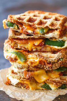 three waffles stacked on top of each other with cheese and vegetables in them