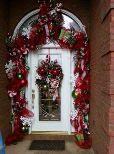 the front door is decorated with red and green christmas decorations