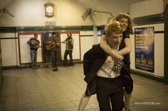 a man carrying a woman on his back in a subway station