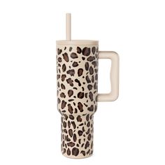 a ceramic cup with a straw in the shape of a leopard print, on a white background