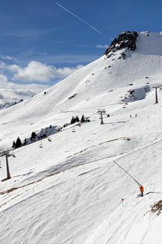 skiers skiing down the side of a snow covered mountain