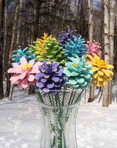 a vase filled with colorful paper flowers in the snow