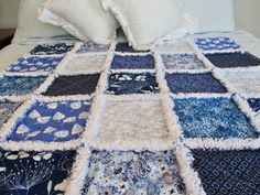 a blue and white patchwork quilt on a bed