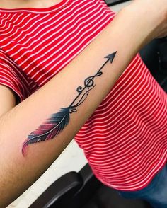 a woman's arm with an arrow tattoo on the left side of her arm