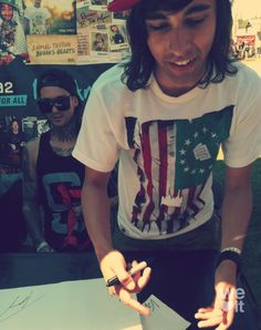 a man with long hair wearing a red hat and holding his hands out in front of him