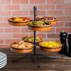 a table topped with plates and bowls filled with different types of food next to a brick wall