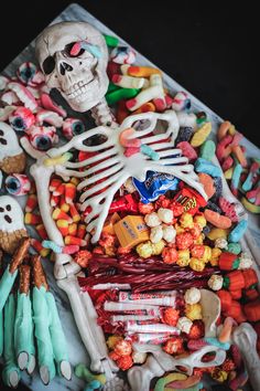 a table topped with lots of candy and skeleton figurines on top of it