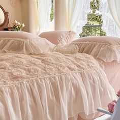 a bed with pink ruffled bedspread and pillows