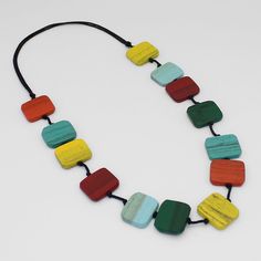 "Elevate your style with our Multi Color Shelby Wood Pendant. Handcrafted with rectangular wood beads in bright multi colors, this statement necklace boasts an artful and comfortable design. Lightweight and created with an adjustable cord, it's the perfect fusion of art and fashion. Indulge in contemporary sophistication with this exclusive piece. Adjustable Length: 26\"-36\"  Bead Width: 1\" Care Instructions: Remove jewelry when applying perfumes, creams, washing hands etc. Do not store in dir Multicolor Rectangular Beaded Necklaces, Adjustable Multicolor Rectangular Beaded Necklaces, Plate Jewelry, Washing Hands, Chunky Statement Necklace, Art And Fashion, Wood Bead Necklace, Necklace Chunky, Wood Necklace