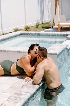 a man and woman are kissing in the pool