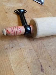 a close up of a wooden object on a table with a cork holder attached to it