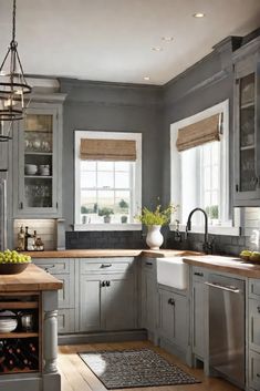 a kitchen with gray cabinets and wooden floors is pictured in this image, there are two windows above the sink