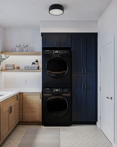 a washer and dryer in a small room with wood cabinets on the walls