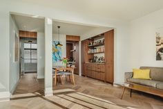 a living room filled with furniture next to a dining room table and bookshelf