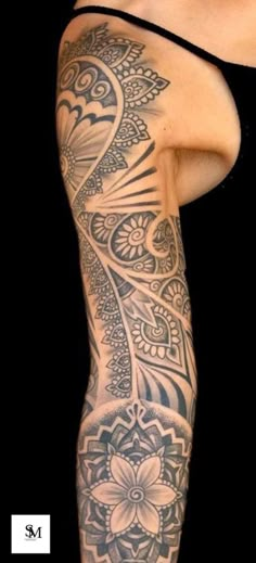 a woman's leg with tattoos on it and an intricate flower design in the middle