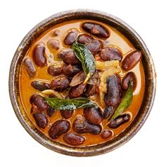 a bowl filled with beans and greens on top of a table