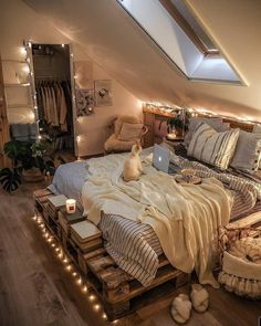 an attic bedroom is decorated with string lights and lots of pillows, blankets, and bedding