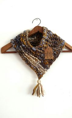 a scarf hanging on a wooden hanger with a tag attached to it's side