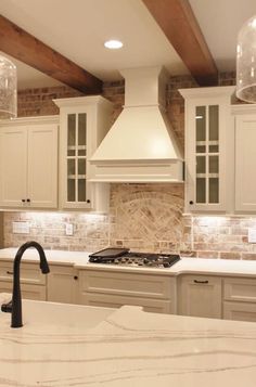 a kitchen with marble counter tops and white cabinets