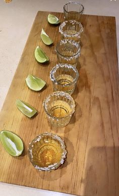 several glasses and limes on a cutting board