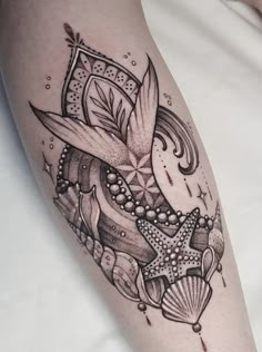 a close up of a person's leg with tattoos on it and an ocean theme