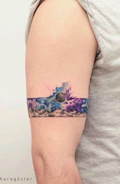 a man with a watercolor tattoo on his arm