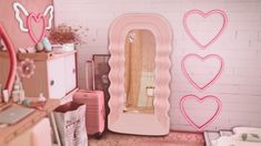 a room with pink furniture and heart shaped mirrors on the wall, along with other items