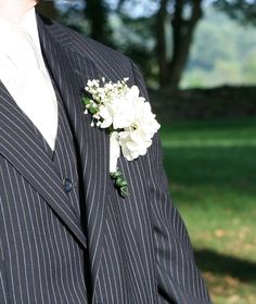 a man in a pinstripe suit with a boutonniere on his lapel