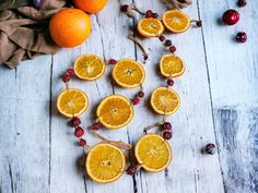 oranges and cranberries arranged in the shape of a heart on a wooden table