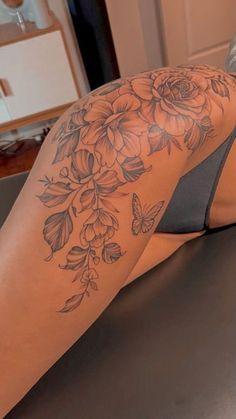 a woman's leg with flowers and butterflies on it