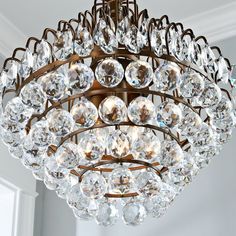 a chandelier hanging from the ceiling with lots of clear crystal beads on it