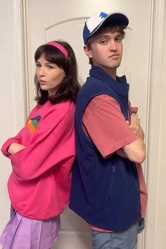 a man and woman standing next to each other in front of a white door wearing colorful clothing