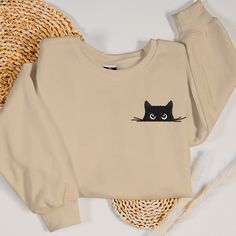 Wrap yourself in feline charm with our Black Cat Sweatshirt, a perfect addition to any cat lover's wardrobe. Design: This cute cat sweatshirt features a beautifully embroidered black cat, making it an eye-catching piece for any occasion. The intricate embroidery showcases the cat's playful and mysterious nature, making it a must-have for any cat lover. Material: Crafted from premium-quality fabric, this embroidered crewneck offers both comfort and durability. Its soft, cozy interior is perfect f Cat Mom Sweatshirt, Embroider Ideas, Cat Sweater, Embroidered Crewneck, Cat Sweatshirt, Intricate Embroidery, Cat Shirt, Embroidered Sweatshirt, Mom Sweatshirt