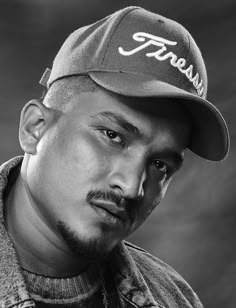 a black and white photo of a man wearing a baseball cap with the word fresh on it