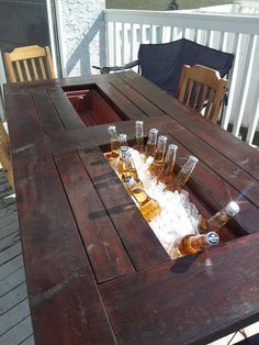 an outdoor table with six bottles of beer on it