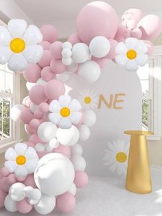 the balloon arch is decorated with white and pink balloons, daisies, and flowers