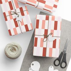 wrapping paper, scissors and twine on a table