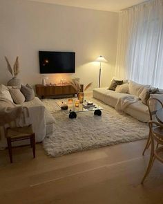 a living room filled with furniture and a flat screen tv mounted to the side of a wall