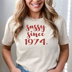 Sassy Since 1974 Shirt, 50th Birthday Gift, 50th Birthday Women Shirts, 1974 Birthday Shirt,Birthday Gift Idea,Funny 1974 Birthday Party Tee ---How To Order --- 1-) Please, check and review all photos 2-) Choose your t-shirt size and color 3-) Click add to cart. You can go back to add more product 4-)Click "Proceed to check out" 5-)When you check out, you can add a note to seller for any request ---Production and Shipping--- * High quality and super soft, comfortable shirt. Made with top-of-the- Retro Short Sleeve Top For Birthday, Vintage White Top For Birthday, Retro Letter Print Tops For Birthday, Retro Summer Tops For Anniversary, Retro Letter Print Tops As Gift, Retro Letter Print Tops For Gifts, Retro Tops With Funny Print As Gift, Vintage Text Print Top For Birthday, 50 Th Birthday Shirts For Women