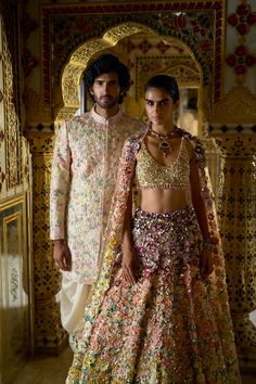 This lehenga set features heavily embroidered three-dimensional embroidery in tones of ivory to yellow to peaches to pinks to plums. The 3D flowers are further accentuated with crystal, bugle beads and platinum-cut sequins. The sleeveless blouse is fully embroidered and shows delicate gold tassels at the waist. It is paired with the heavily embroidered dupatta having a matching border and floral motifs all over. From Seema Gujral's Palace of Dreams collection. DELIVERY TIMEPlease allow 8-12 weeks for your outfit to arrive. FABRIC DETAILSNet Professional cleaning only. Afghani Salwar, Silk Kurta, Bugle Beads, 12 Weeks, Sherwani, Professional Cleaning, Raw Silk, Sleeveless Blouse