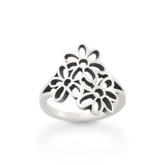 a silver ring with black and white flowers on the front, sitting on a white surface