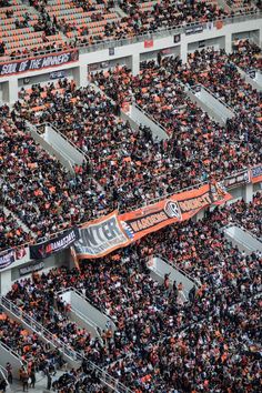 an orange and black banner is in the middle of a stadium full of people,