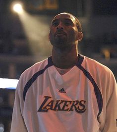 a basketball player is looking up at the sky with his head turned to the side