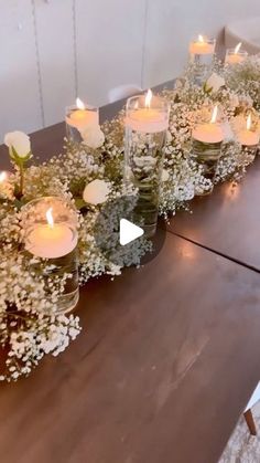 a long table with flowers and candles on it is shown in front of the camera