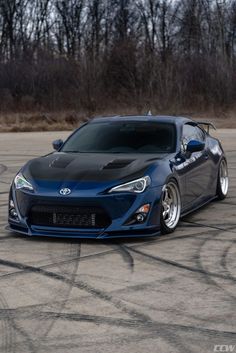 a blue sports car parked on top of a parking lot