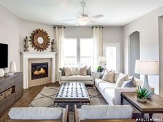 a living room filled with furniture and a fire place in front of a tv mounted on a wall