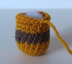 a small crocheted yellow and brown object with a string attached to the end