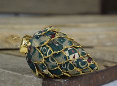 a green and gold purse sitting on top of a piece of wood next to a door