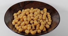 a brown bowl filled with chickpeas on top of a table